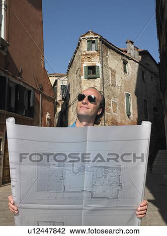 Man looking at blue prints in the street View Large Photo Image Stock Image - Man looking at blue prints in the street. Fotosearch