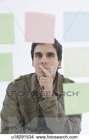 Man looking at different coloured post-it notes View Large Photo Image Picture - Man looking at different coloured post-it notes. Fotosearch