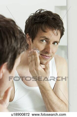 Man moisturizing face in bathroom View Large Photo Image Stock Image - Man moisturizing face in bathroom. Fotosearch
