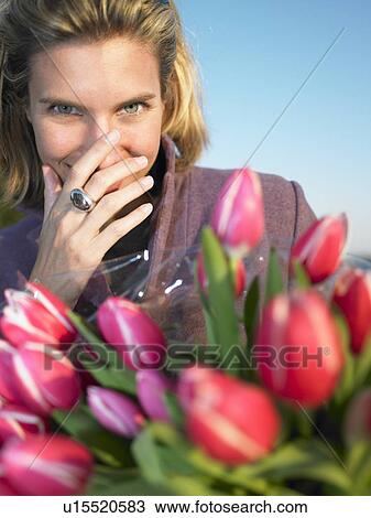 Man offering flowers to a woman View Large Photo Image Stock Image - Man offering flowers to a woman. Fotosearch