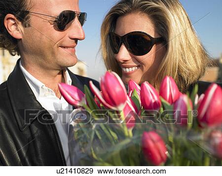 Man offering flowers to a woman View Large Photo Image Stock Photo - Man offering flowers to a woman. Fotosearch