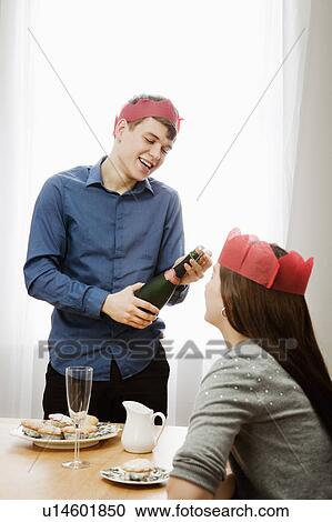 Stock Image - Man opening bottle of champagne. Fotosearch