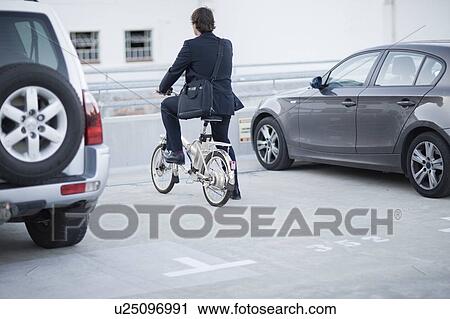 Stock Image - Man parking his bicycle. Fotosearch