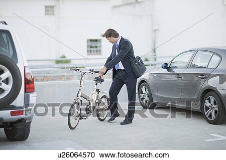 Stock Image - Man parking his bicycle. Fotosearch