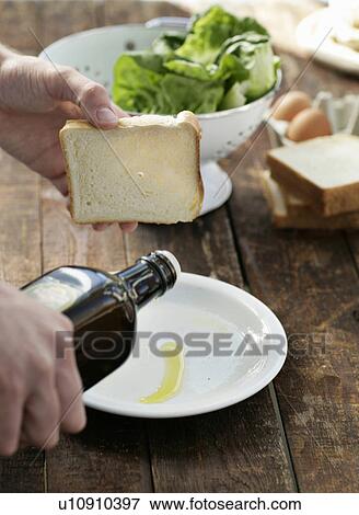 Man pouring olive oil onto plate View Large Photo Image Stock Photo - Man pouring olive oil onto plate. Fotosearch