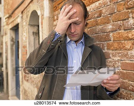 Picture - Man reading a letter. Fotosearch