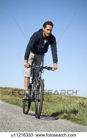 Man riding his bike View Large Photo Image Stock Image - Man riding his bike. Fotosearch