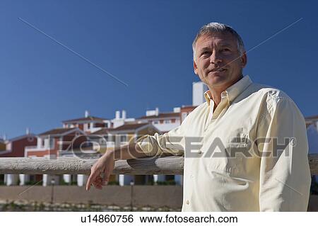 Man standing by property development View Large Photo Image Stock Photograph - Man standing by property development. Fotosearch