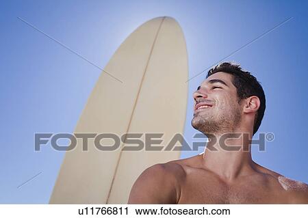 Man standing with surfboard View Large Photo Image Stock Image - Man standing with surfboard. Fotosearch