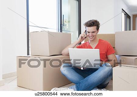Man using laptop in new home View Large Photo Image Picture - Man using laptop in new home. Fotosearch