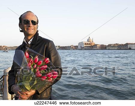 Stock Photograph - Man with a bouquet in his hands. Fotosearch