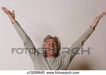 Stock Image - Man with arms raised in celebration. Fotosearch