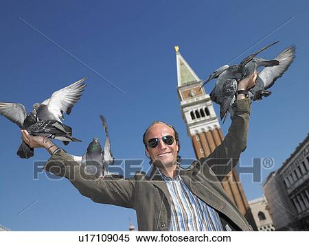Stock Photography - Man with pigeons on his hands. Fotosearch