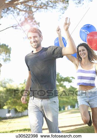Man woman running with balloons View Large Photo Image Stock Photo - Man woman running with balloons. Fotosearch