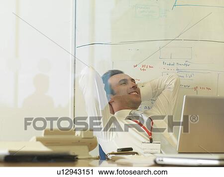 Man working at desk View Large Photo Image Stock Image - Man working at desk. Fotosearch