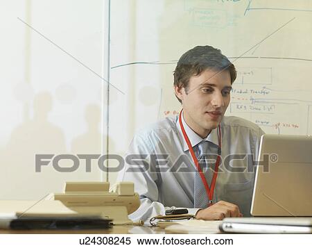 Stock Photography - Man working at desk. Fotosearch