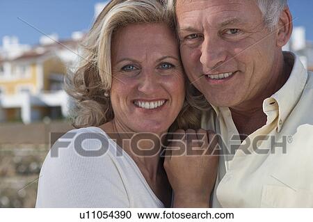 Stock Image - Mature couple by property development. Fotosearch