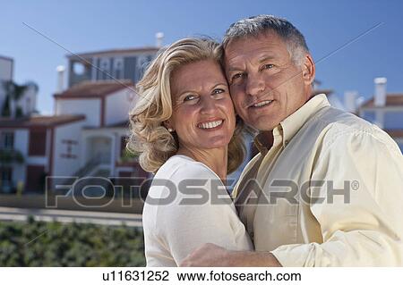 Stock Image - Mature couple by property development. Fotosearch