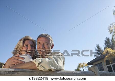 Stock Photo - Mature couple embracing and smiling. Fotosearch