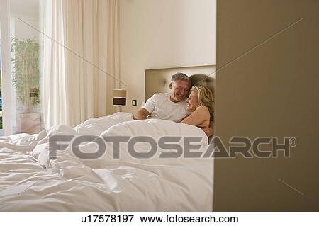 Mature couple embracing tenderly in bed View Large Photo Image Stock Photo - Mature couple embracing tenderly in bed. Fotosearch