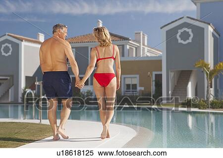 Mature couple strolling by pool View Large Photo Image Stock Photography - Mature couple strolling by pool. Fotosearch