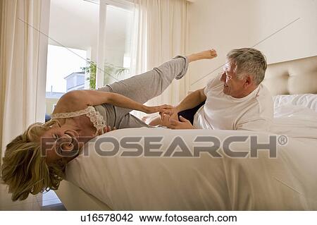 Mature couple wrestling on bed View Large Photo Image Stock Image - Mature couple wrestling on bed. Fotosearch