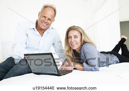 Stock Image - Middle aged couple with laptop. Fotosearch