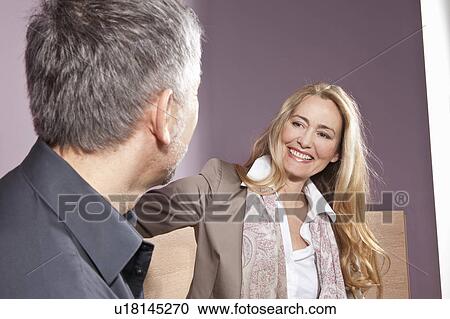 Middle aged woman smiling at man View Large Photo Image Stock Image - Middle aged woman smiling at man. Fotosearch
