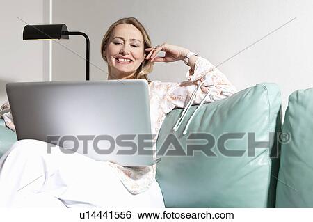 Stock Photograph - Middle aged woman using laptop. Fotosearch