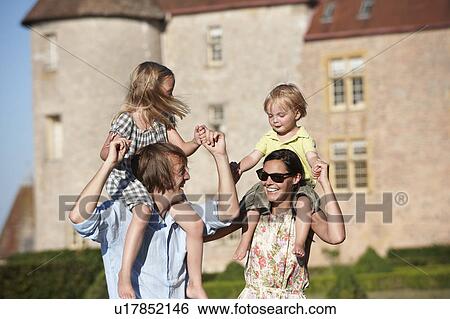 Mom and dad with kids on their shoulders View Large Photo Image Stock Photograph - Mom and dad with kids on their shoulders. Fotosearch