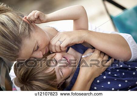 Stock Image - Mom hugging kid. Fotosearch