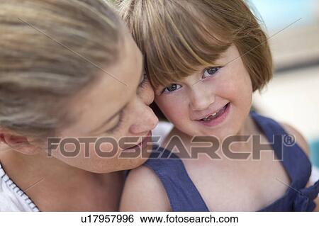 Stock Photograph - Mom hugging kid. Fotosearch