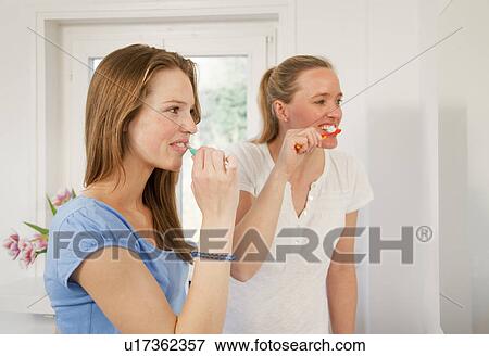 Stock Photo - Mother and daughter brushing their teeth. Fotosearch