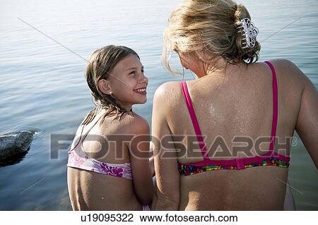 Mother and daughter chatting by lake View Large Photo Image Stock Image - Mother and daughter chatting by lake. Fotosearch