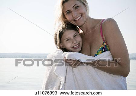 Stock Image - Mother and daughter in towel, portrait. Fotosearch