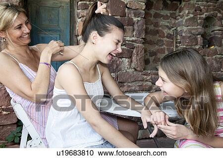 Stock Image - Mother and daughters laughing together. Fotosearch
