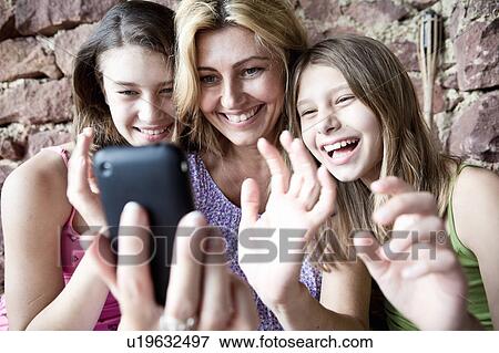 Stock Photo - Mother and daughters video call on phone. Fotosearch