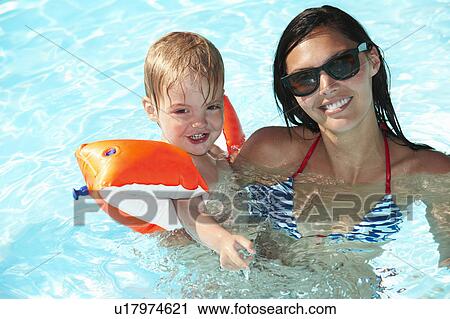 Mother and son playing in swimming pool View Large Photo Image Stock Image - Mother and son playing in swimming pool. Fotosearch