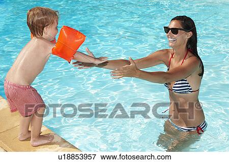 Stock Photo - Mother and son playing in swimming pool. Fotosearch