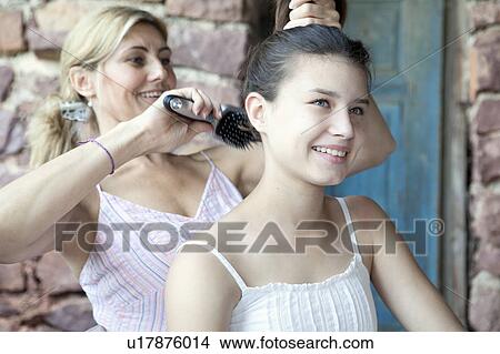 Mother brushing daughter's hair View Large Photo Image Picture - Mother brushing daughter's hair. Fotosearch