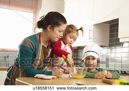 Mother cooking with children in kitchen View Large Photo Image Stock Image - Mother cooking with children in kitchen. Fotosearch