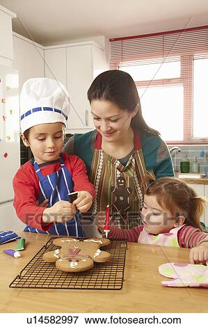 Mother cooking with children in kitchen View Large Photo Image Stock Photo - Mother cooking with children in kitchen. Fotosearch
