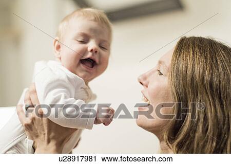 Stock Image - Mother holding baby up in the air. Fotosearch