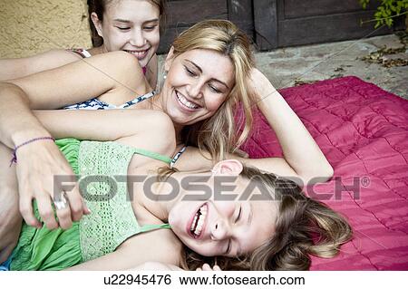 Stock Photograph - Mother tickling daughters. Fotosearch