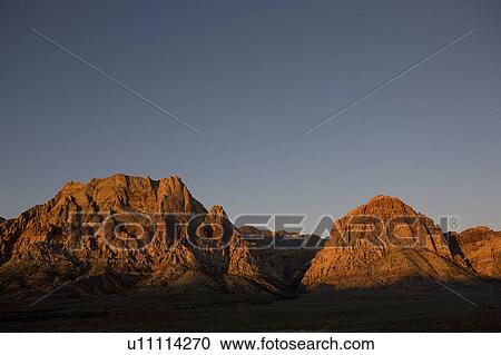 Stock Image - Mountains in sunrise with blue sky. Fotosearch
