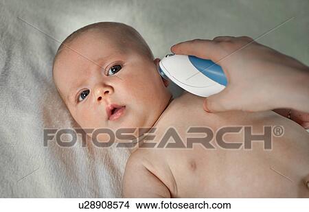 Picture - Mum checking temperature to her newborn. Fotosearch