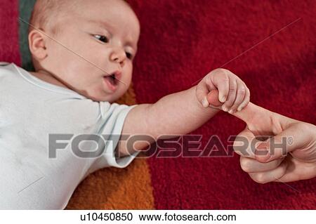 Stock Image - Newborn boy holds his mum's finger. Fotosearch