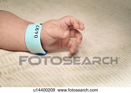 Stock Photo - Newborn boy with hospital bracelet. Fotosearch