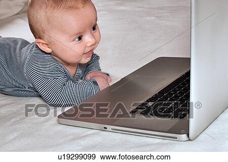 Stock Photo - Newborn boy with laptop. Fotosearch