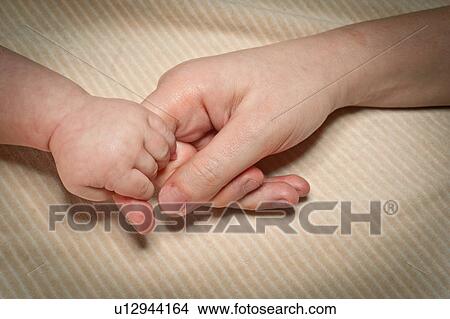Picture - Newborn holds mum's finger. Fotosearch